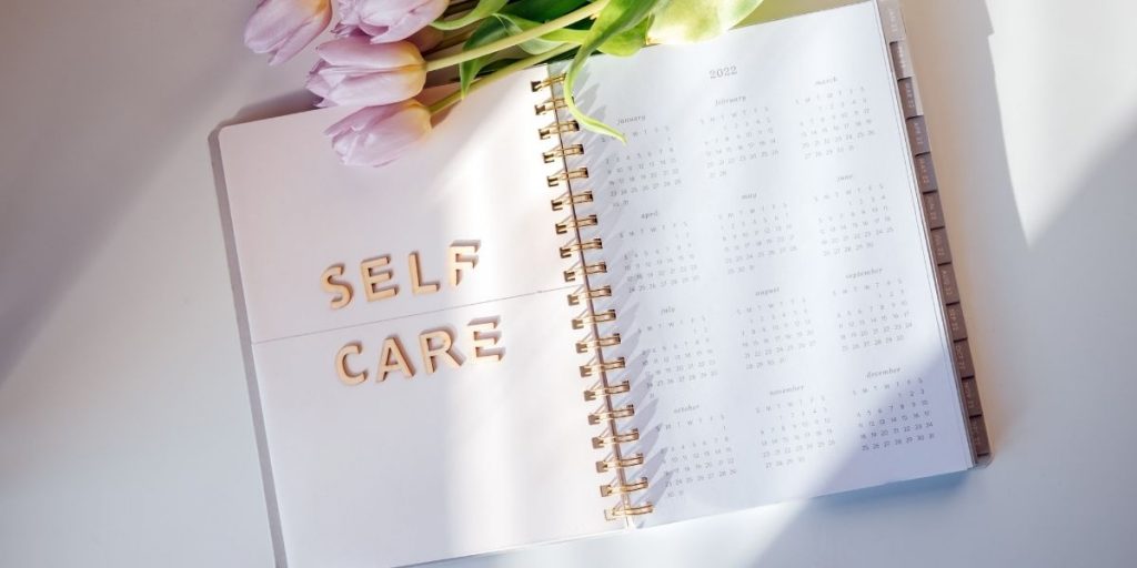 Foto van een agenda met daarop heel groot 'Self care', zelfzorg is belangrijk om in te plannen